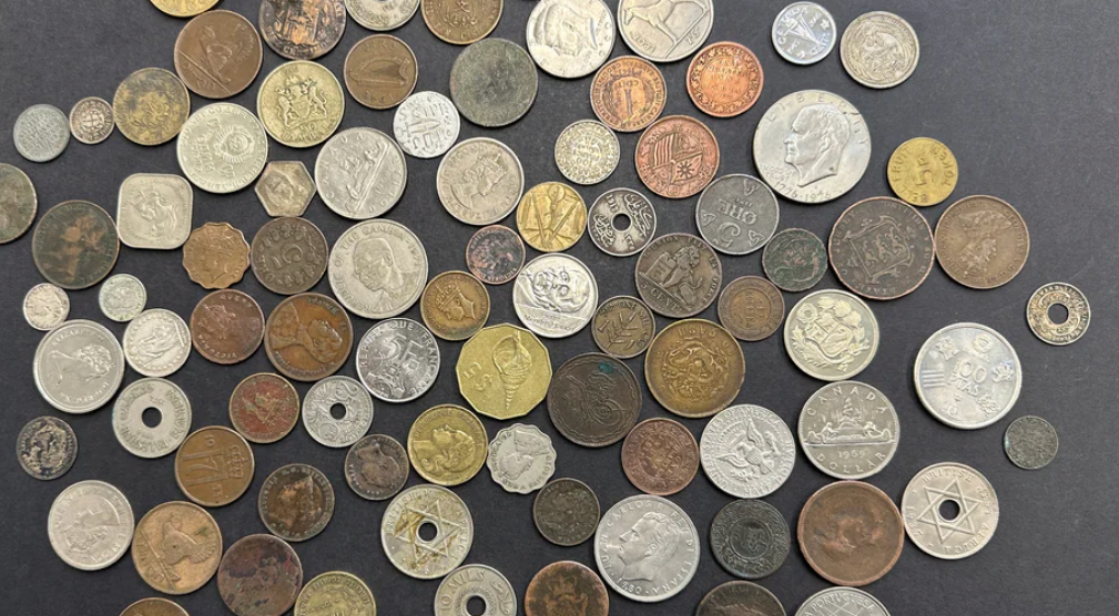 Selection of world coins laid out on a piece of black card